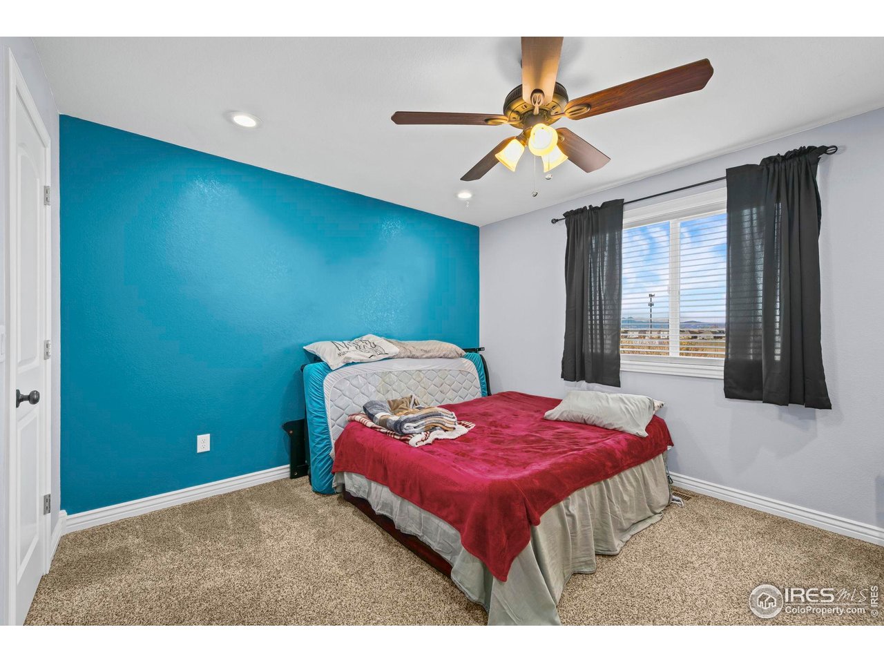 1302 Park Ridge Drive Severance, CO 80615 - Photo 24 of 35 a bedroom with a bed and a chandelier