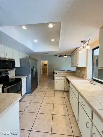a large kitchen with stainless steel appliances lots of counter space and a sink