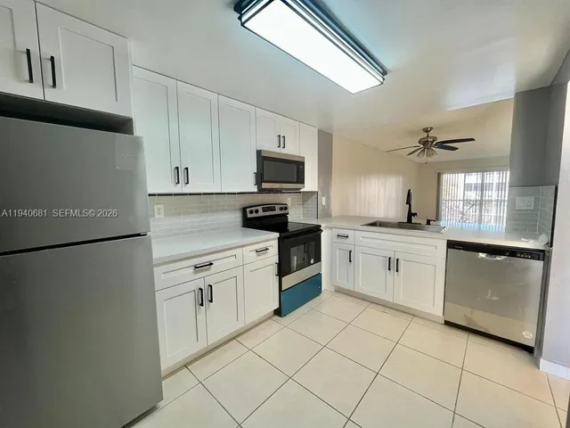 a kitchen with white cabinets and white appliances