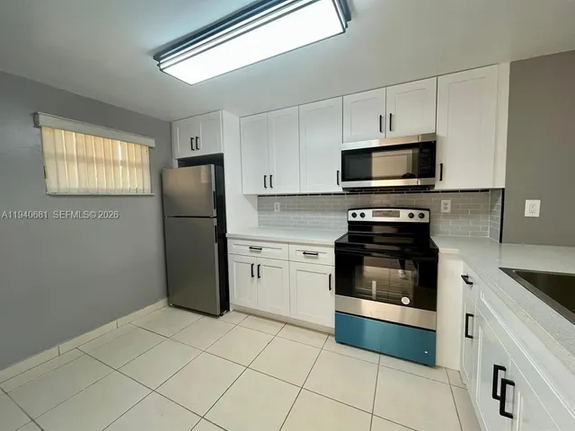 a kitchen with a refrigerator stove and microwave