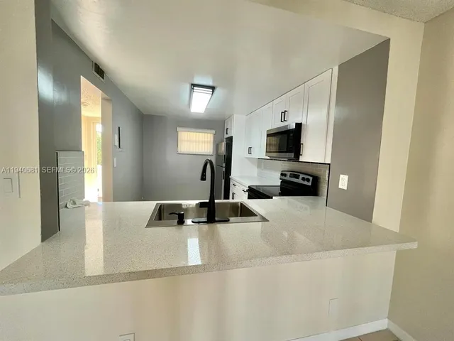a kitchen with a sink and a refrigerator