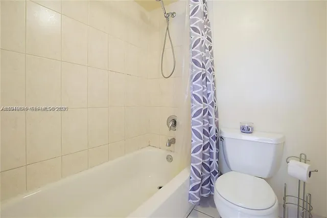 a white toilet sitting next to a bath tub