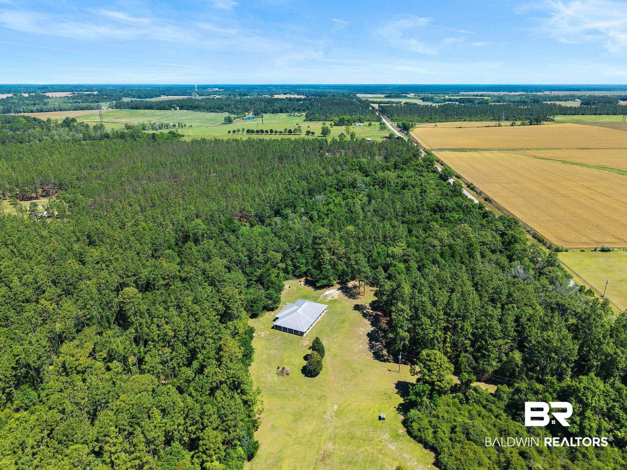 20219 Greek Cemetery Road Robertsdale, AL 36567 - Photo 40 of 41 Expansive aerial property featuring a single-story residence with a light-colored roof, surrounded by mature trees and open fields
