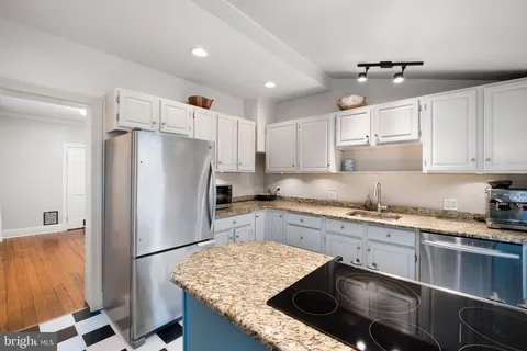 a kitchen with a refrigerator sink and cabinets