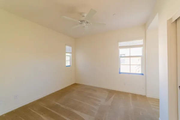 an empty room with a ceiling fan and a window