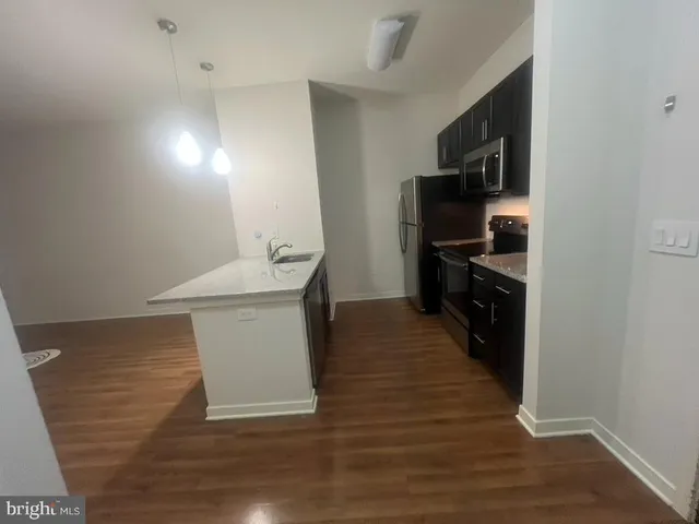 a kitchen with stainless steel appliances kitchen island granite countertop a refrigerator a sink and a stove