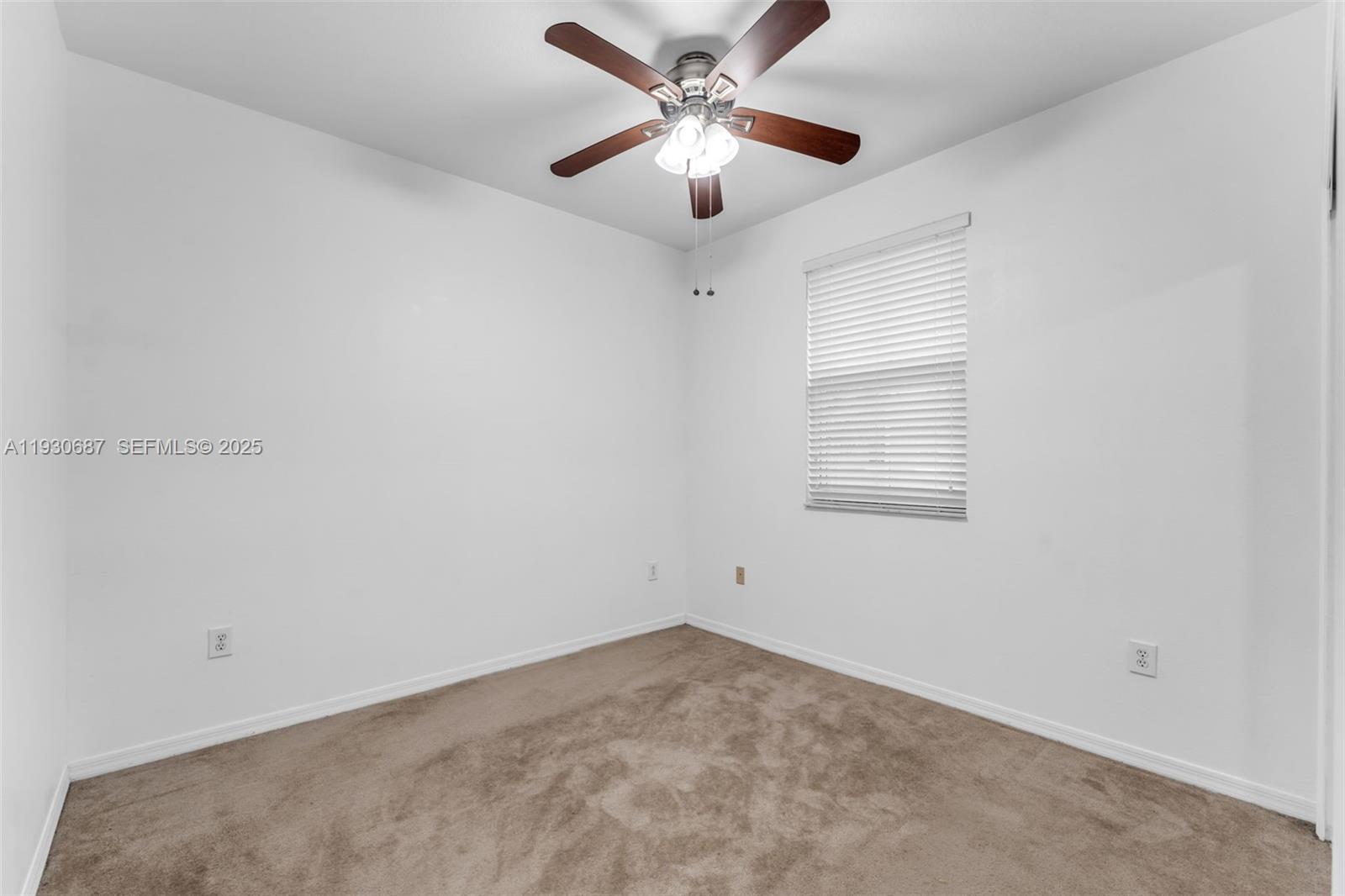 13820 Southwest 275th Street Homestead, FL 33032 - Photo 16 of 36 a view of a room with a ceiling fan and a window