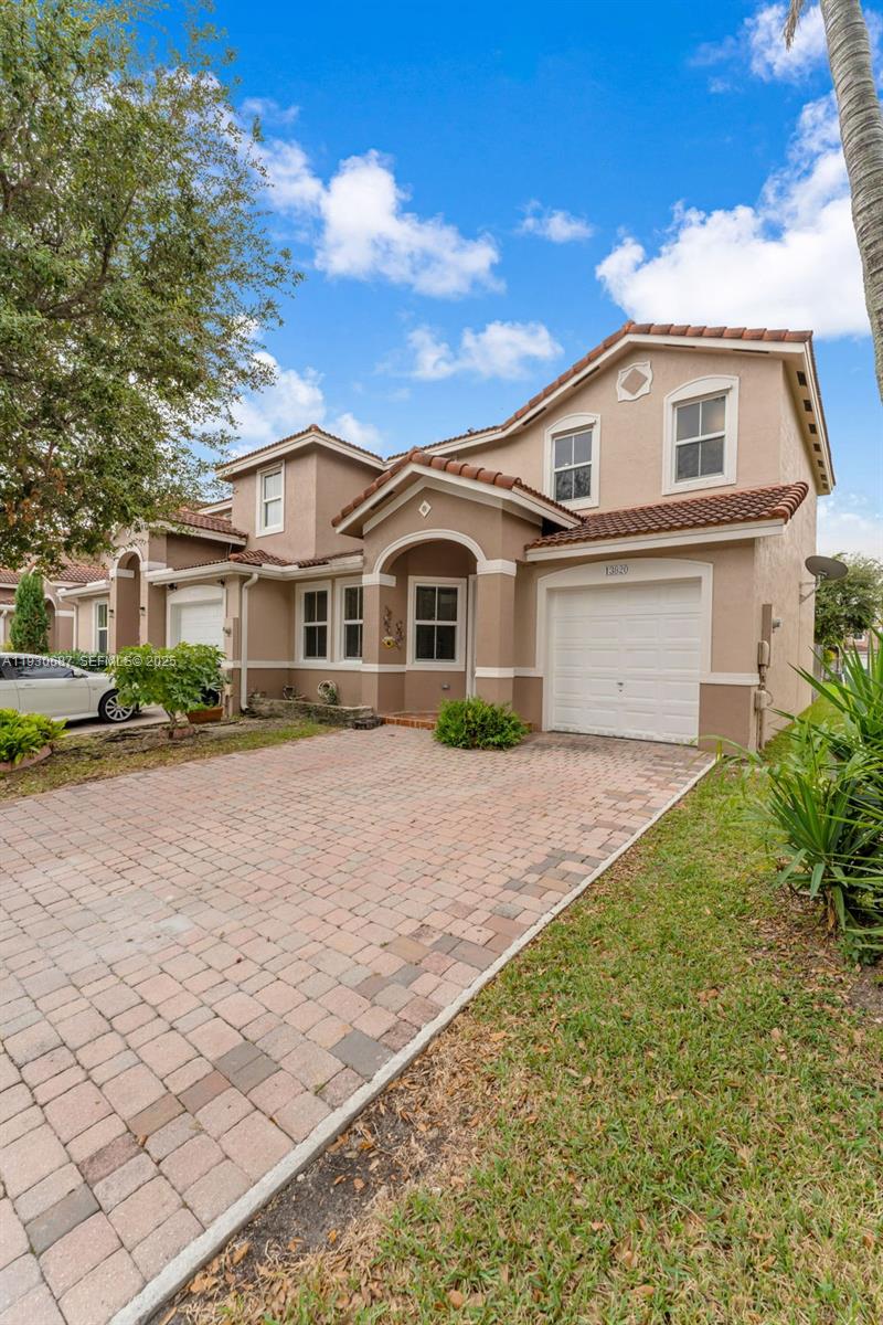 13820 Southwest 275th Street Homestead, FL 33032 - Photo 2 of 36 a front view of a house with a yard and potted plants