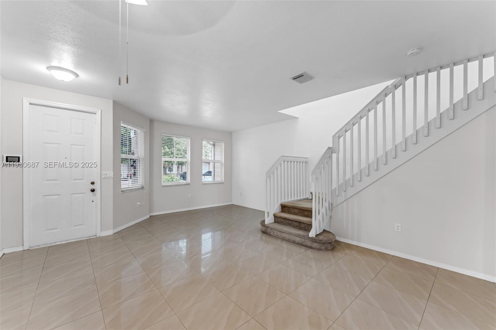 13820 Southwest 275th Street Homestead, FL 33032 - Photo 4 of 36 a view of an empty room with stairs and a window