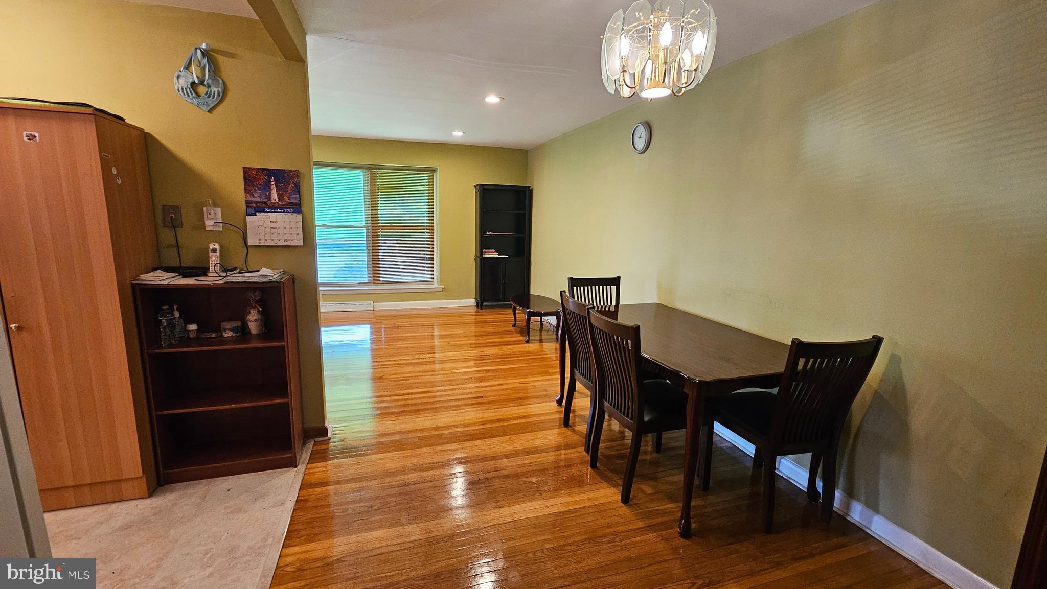 635 Colebrook Road Philadelphia, PA 19115 - Photo 28 of 31 a dining room with wooden floor a chandelier a wooden table and chairs