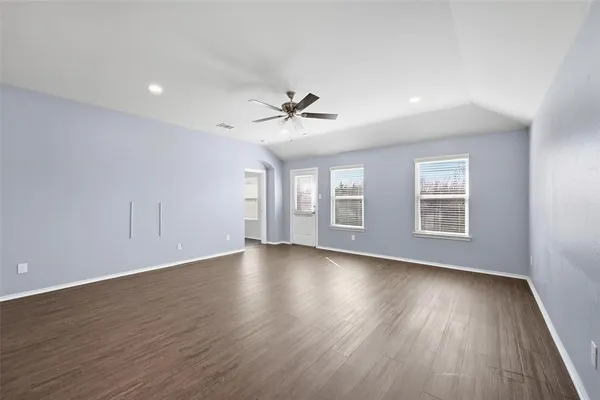 a view of an empty room with a window and wooden floor