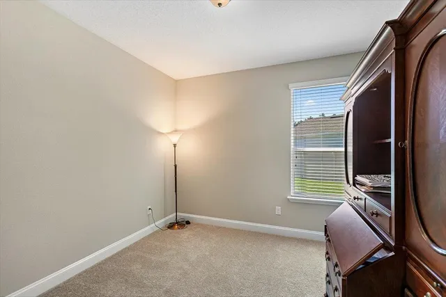 a bedroom with bed and paintings on the wall