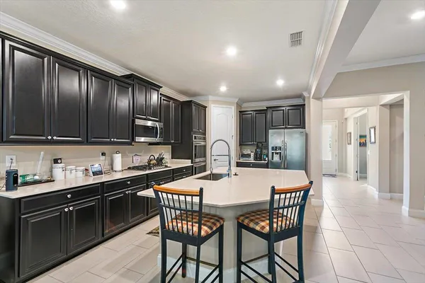 a kitchen with granite countertop a center island a sink stainless steel appliances and cabinets