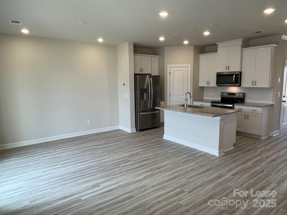 3703 Backwater Street Concord, NC 28027 - Photo 6 of 23 a kitchen with stainless steel appliances a refrigerator and a stove top oven