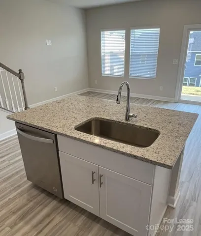 a kitchen with granite countertop a sink and a window