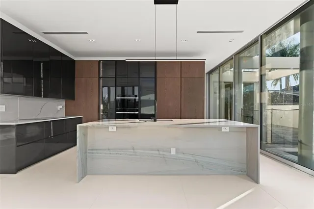 a kitchen with stainless steel appliances kitchen island granite countertop a refrigerator and a sink