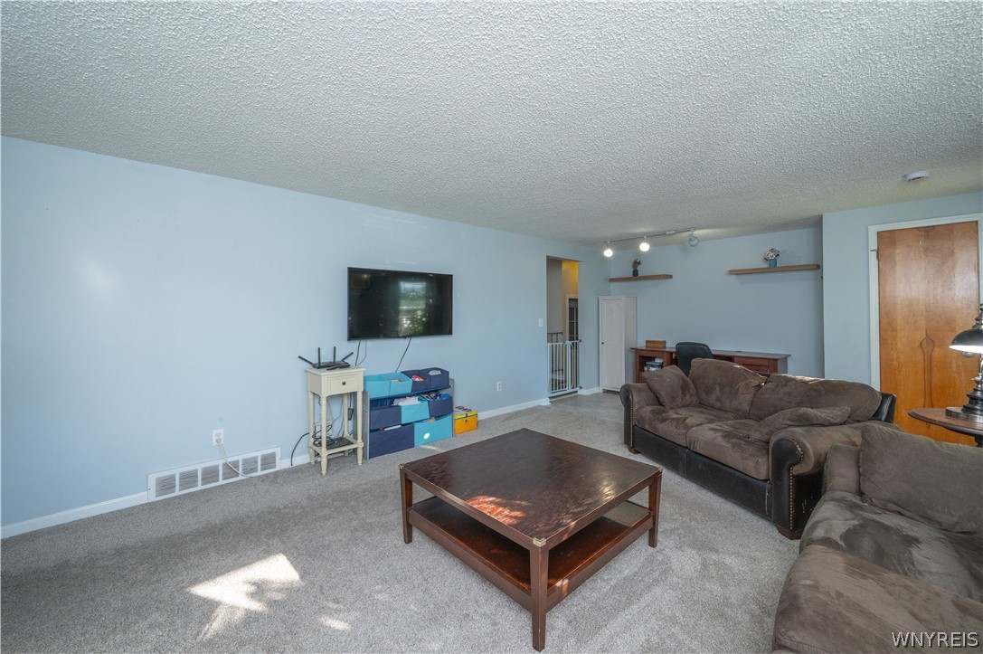 6463 Ward Road Sanborn, NY 14132 - Photo 8 of 49 Soft carpeting pairs with smooth plaster walls in this versatile living space.