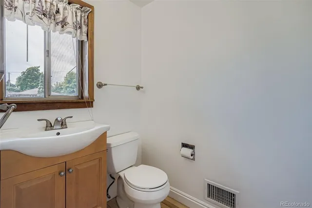 a bathroom with a sink a toilet and a mirror