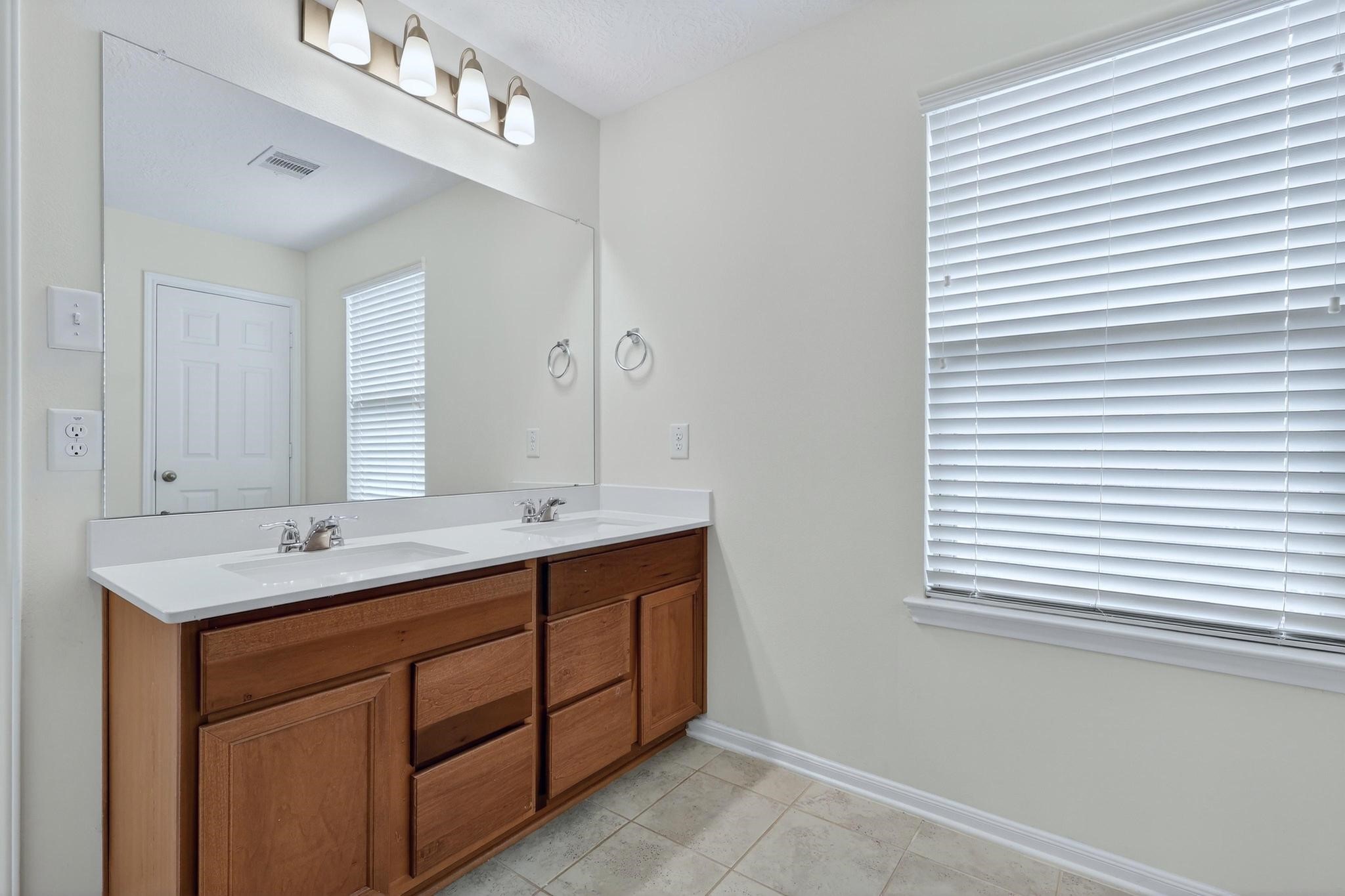 3322 Nila Creek Dr Spring Spring, TX 77373 - Photo 21 of 36 Primary bathroom vanity area offering generous counter space and natural light from the nearby window.