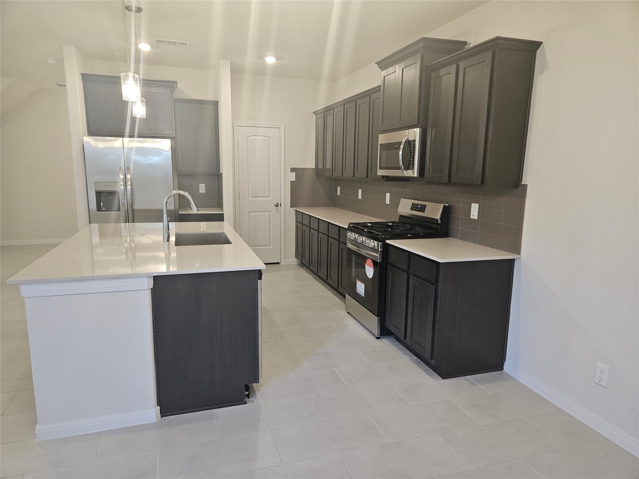 7971 Cypress Country Drive Cypress, TX 77433 - Photo 6 of 7 a kitchen with stainless steel appliances granite countertop a sink stove and refrigerator
