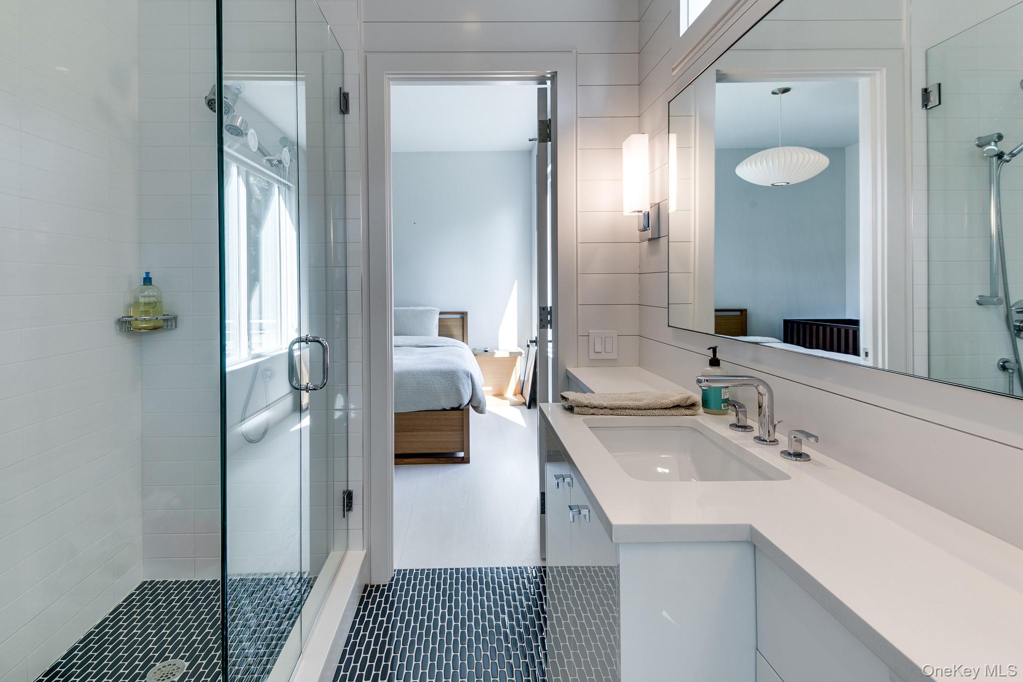 70 Cove Hollow Road East Hampton, NY 11937 - Photo 19 of 21 Ensuite bathroom with a stall shower, vanity, tile patterned floors, and tile walls