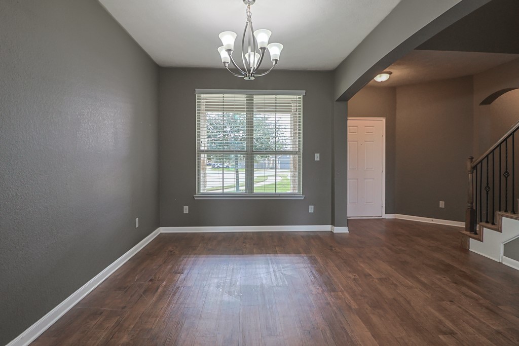 3040 Positano Loop Bryan, TX 77808 - Photo 6 of 20 Unfurnished dining area featuring dark hardwood / wood-style floors and an inviting chandelier