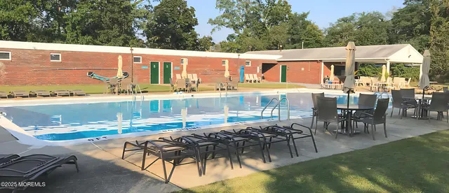 a view of a patio with table and chairs floor to ceiling window and outdoor kitchen