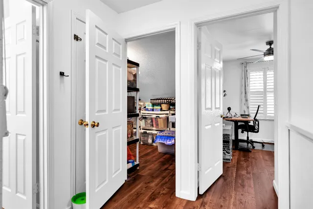 a view of a hallway with wooden floor and dining room