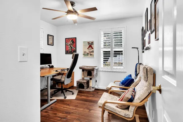 a view of a workspace with furniture and a window