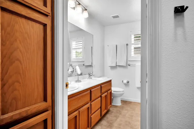 a bathroom with a double vanity sink toilet and shower