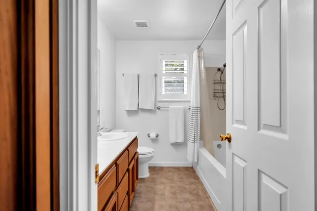a view of a hallway with wooden floor and cabinet