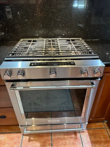 a stove top oven sitting inside of a kitchen