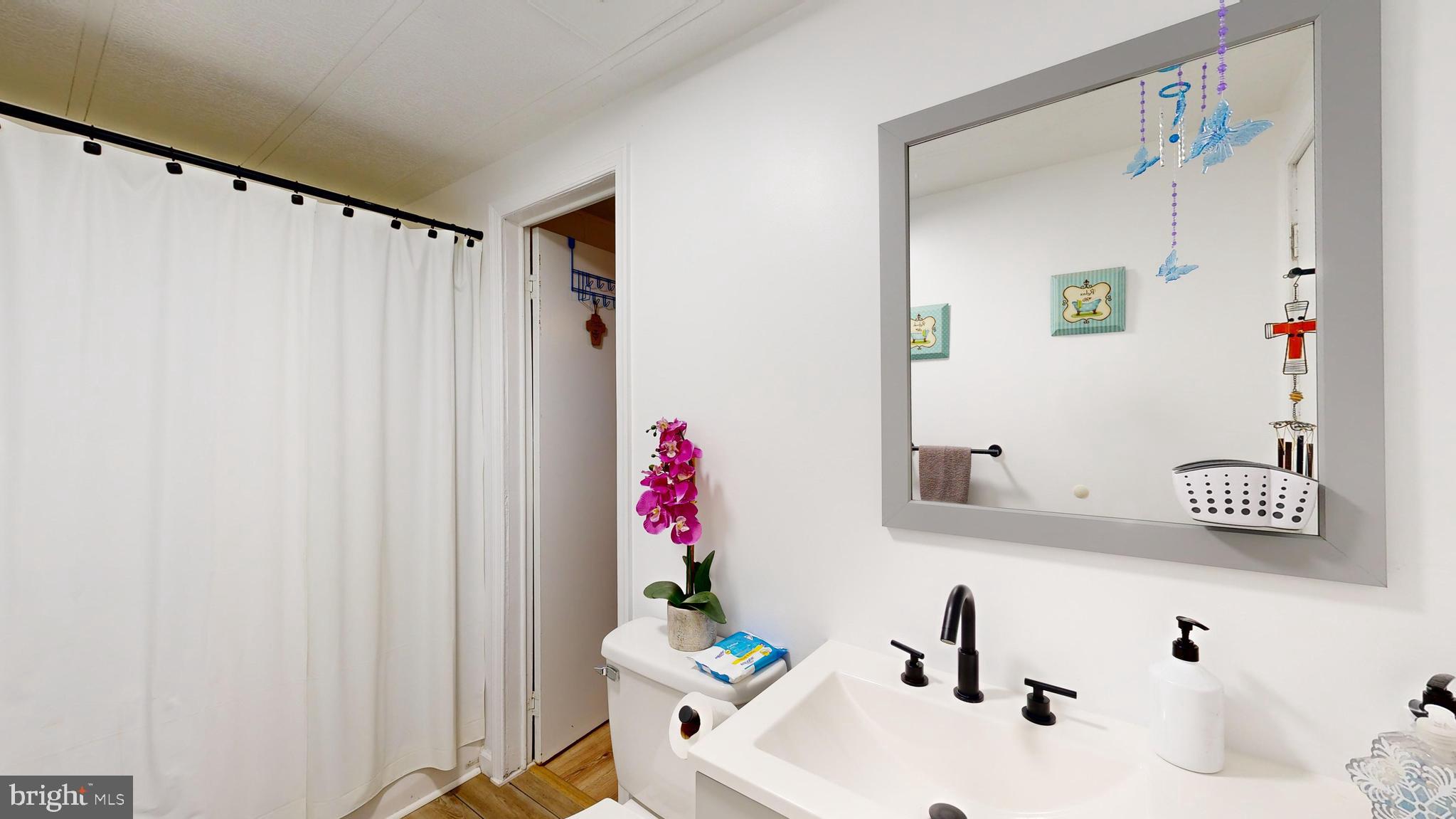 17261 Ridge Line Drive, Unit 18007 Lewes, DE 19958 - Photo 23 of 38 a bathroom with a sink and a mirror