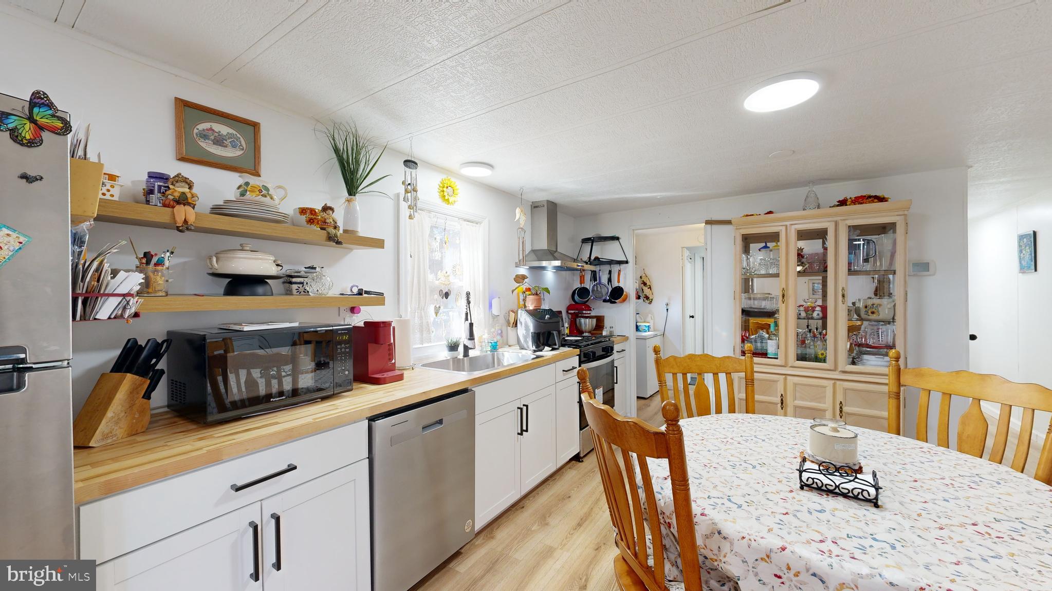 17261 Ridge Line Drive, Unit 18007 Lewes, DE 19958 - Photo 25 of 38 a kitchen with stainless steel appliances granite countertop a sink and dishwasher a refrigerator with wooden floor