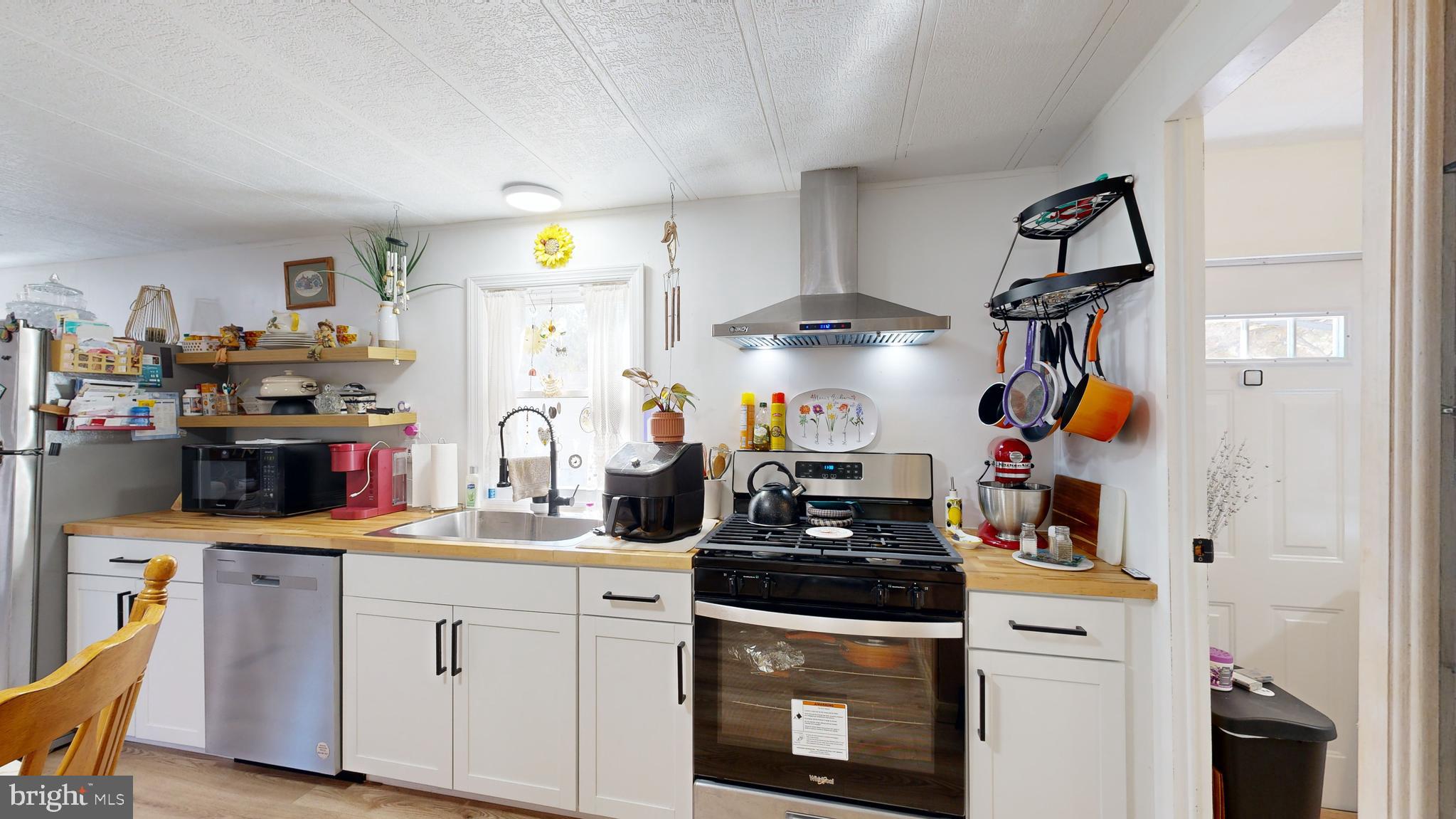17261 Ridge Line Drive, Unit 18007 Lewes, DE 19958 - Photo 26 of 38 a kitchen with a sink dishwasher and a stove with wooden floor
