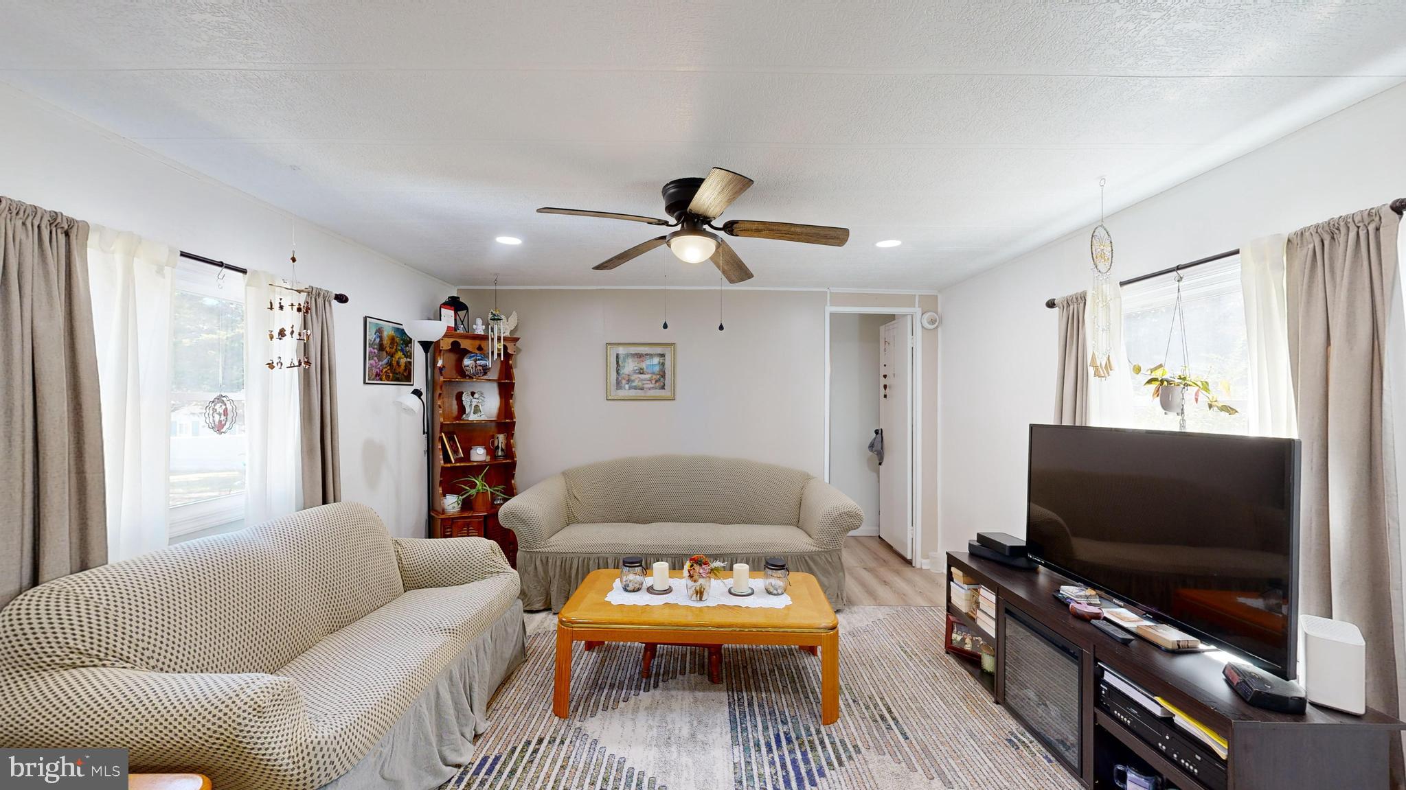 17261 Ridge Line Drive, Unit 18007 Lewes, DE 19958 - Photo 29 of 38 a living room with furniture and a flat screen tv