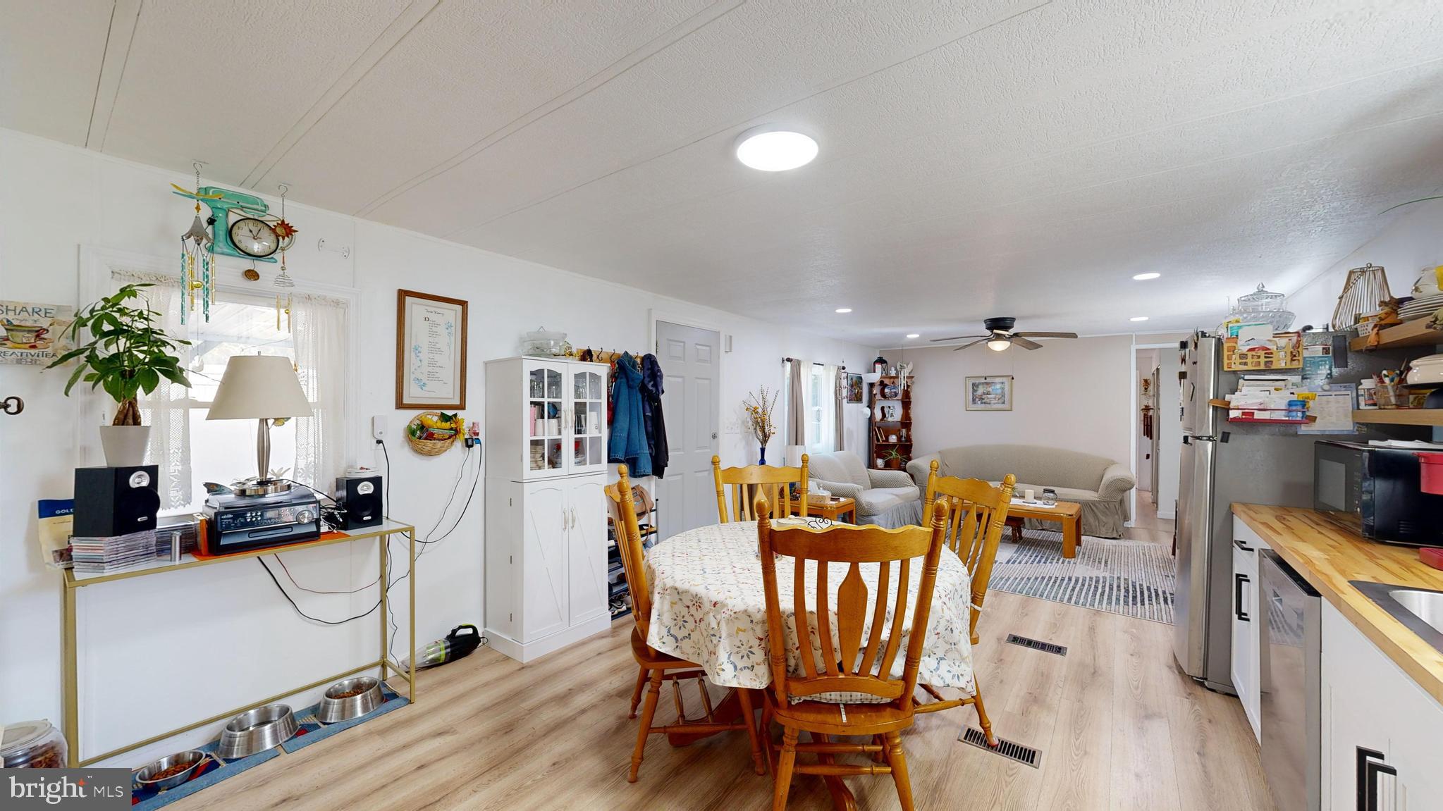 17261 Ridge Line Drive, Unit 18007 Lewes, DE 19958 - Photo 2 of 38 a living room with furniture a dining table and chairs with wooden floor