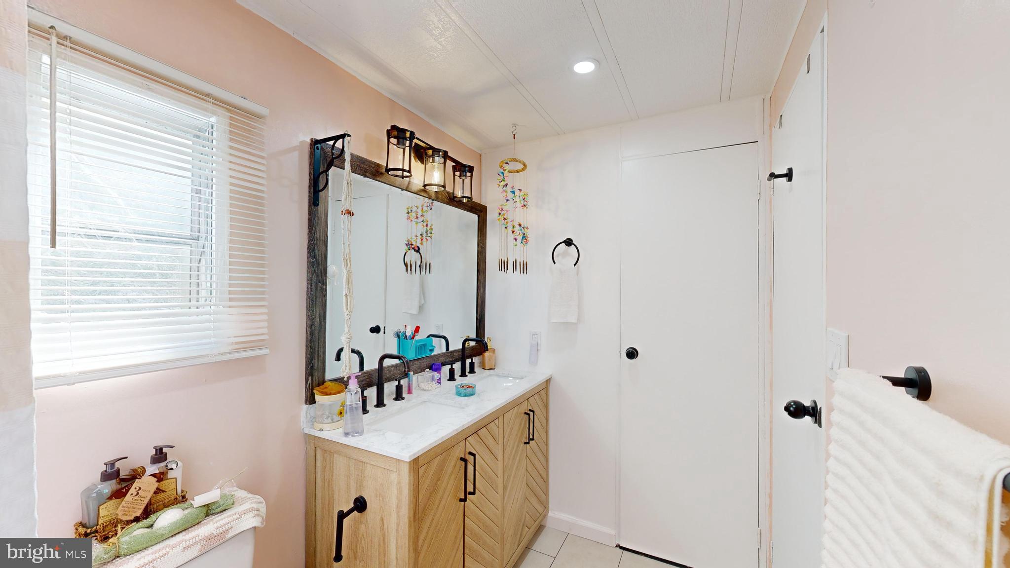 17261 Ridge Line Drive, Unit 18007 Lewes, DE 19958 - Photo 31 of 38 a bathroom with a sink mirror and vanity