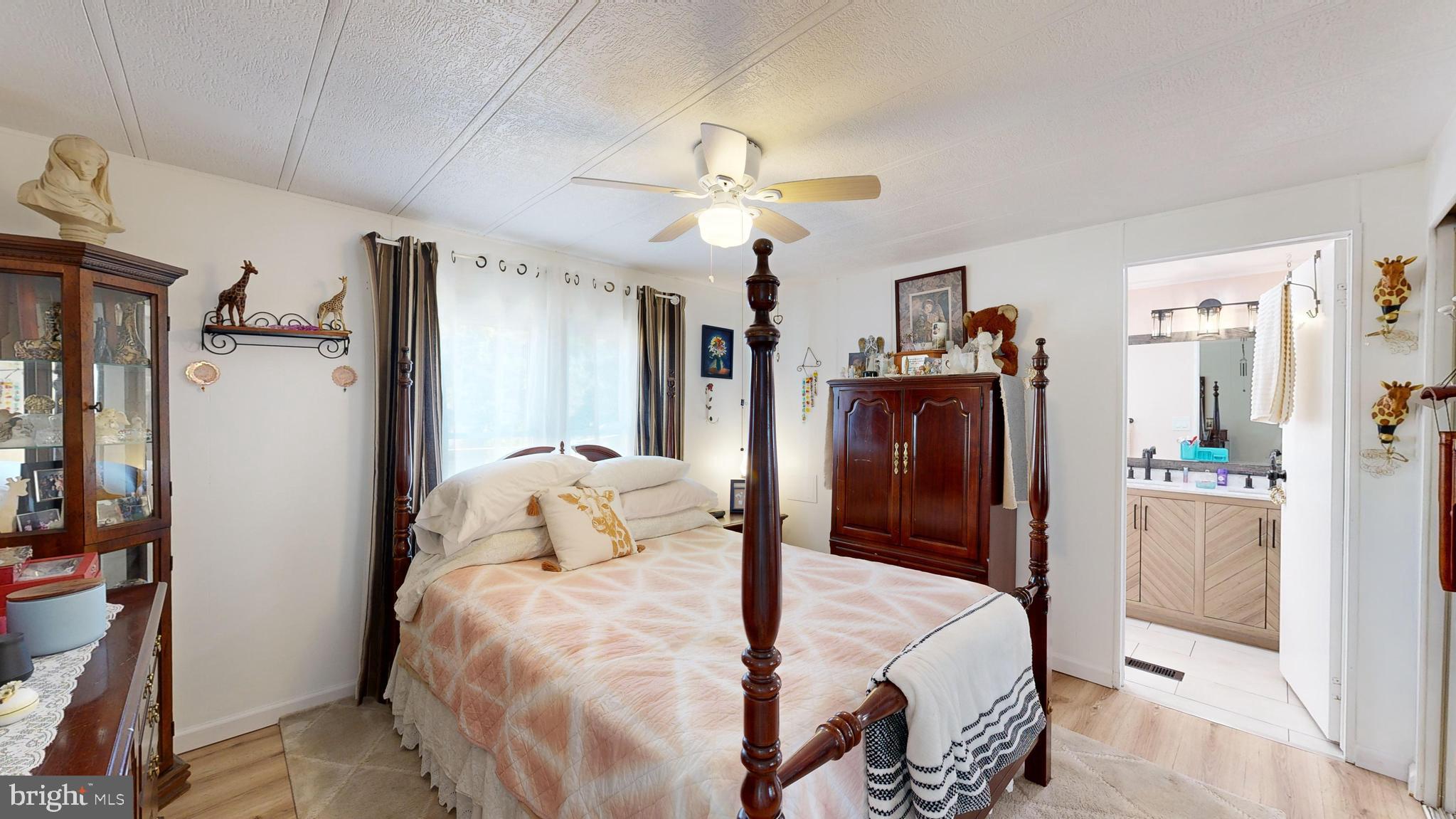 17261 Ridge Line Drive, Unit 18007 Lewes, DE 19958 - Photo 34 of 38 a bedroom with a bed and a chandelier