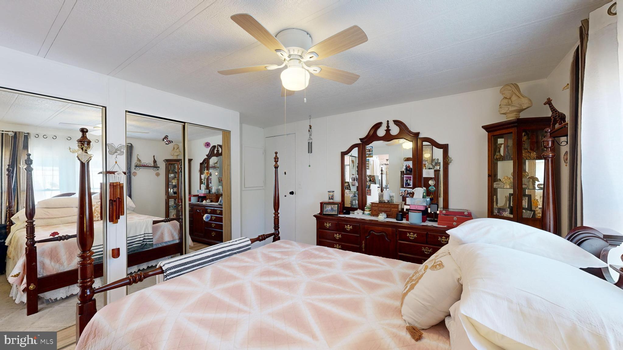 17261 Ridge Line Drive, Unit 18007 Lewes, DE 19958 - Photo 35 of 38 a bedroom with a bed mirror on dresser and a large mirror