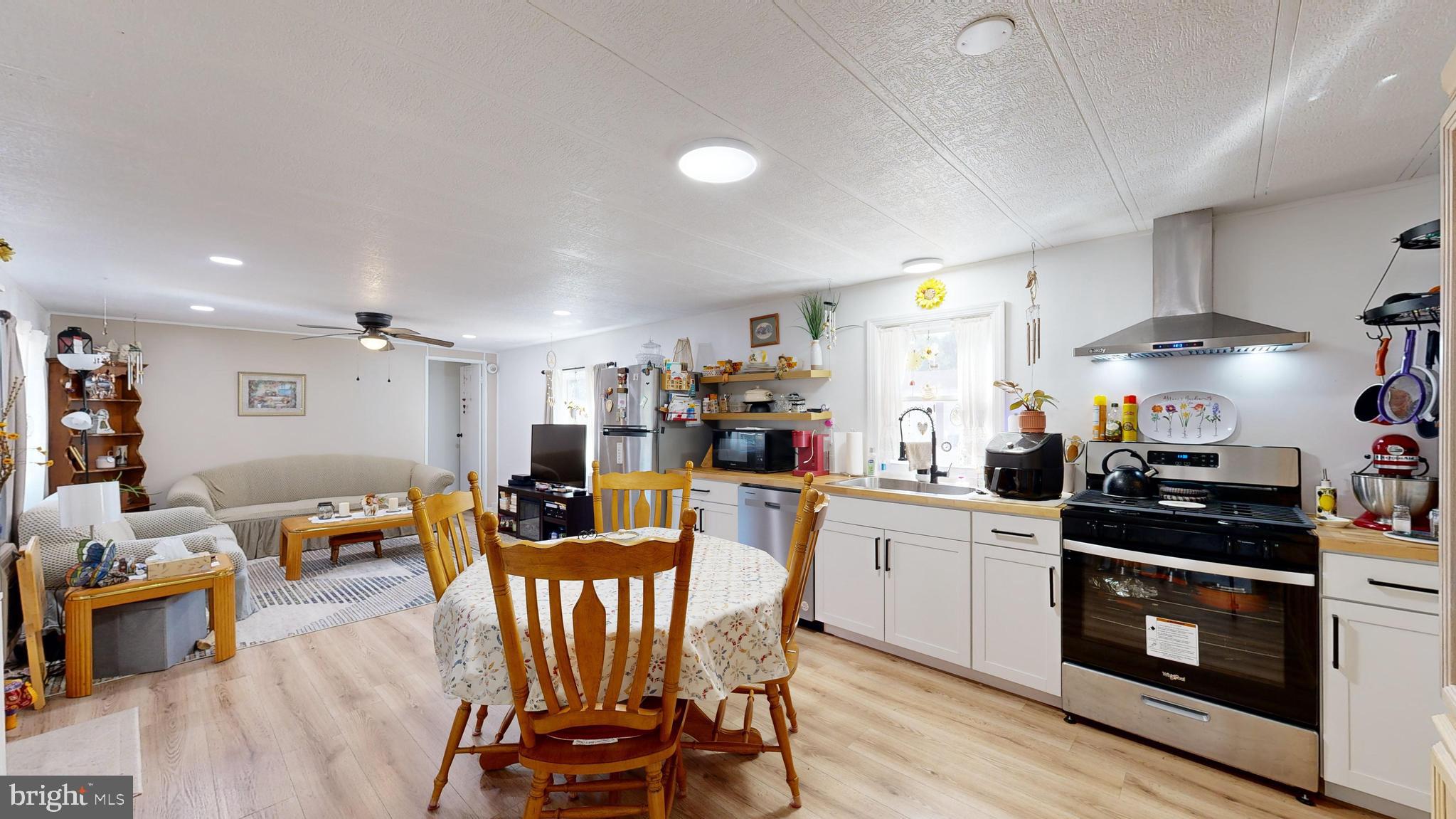 17261 Ridge Line Drive, Unit 18007 Lewes, DE 19958 - Photo 3 of 38 a kitchen with stainless steel appliances a dining table chairs stove and white cabinets