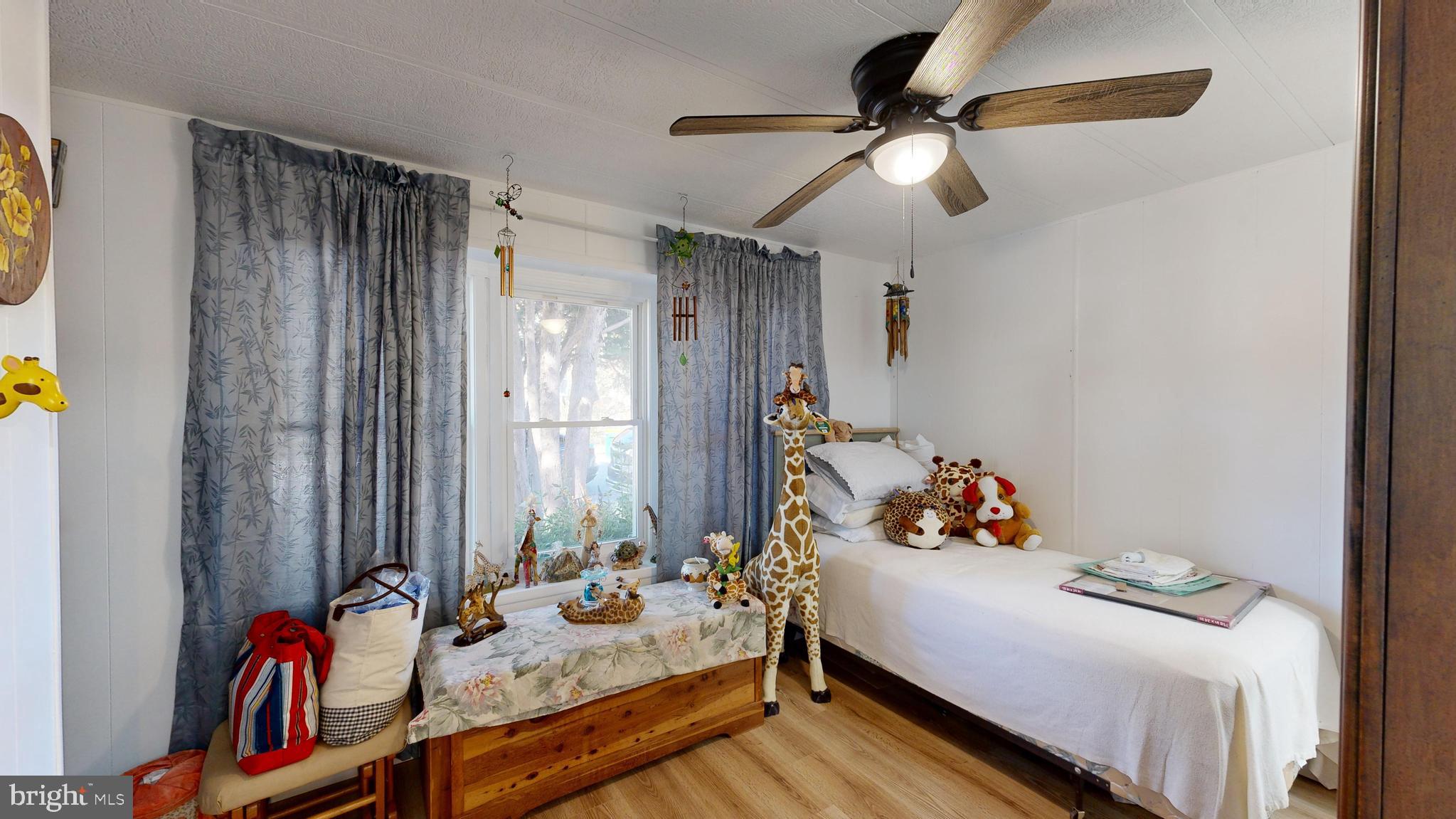 17261 Ridge Line Drive, Unit 18007 Lewes, DE 19958 - Photo 8 of 38 a bedroom with a bed and a chandelier