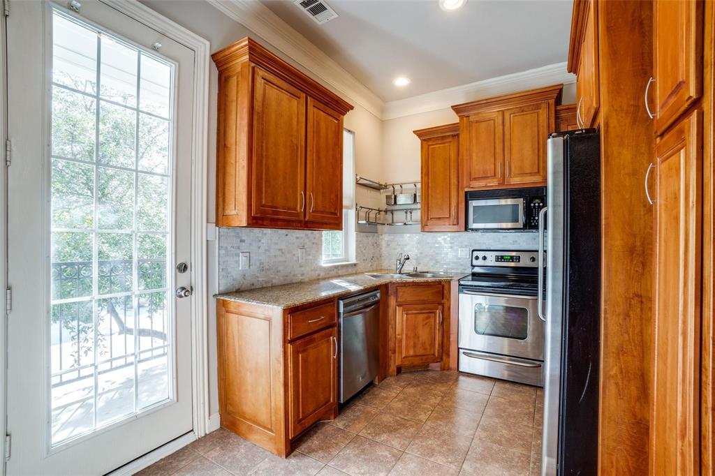 5827 Lewis Street Dallas, TX 75206 - Photo 3 of 24 a kitchen with stainless steel appliances granite countertop a refrigerator and a sink