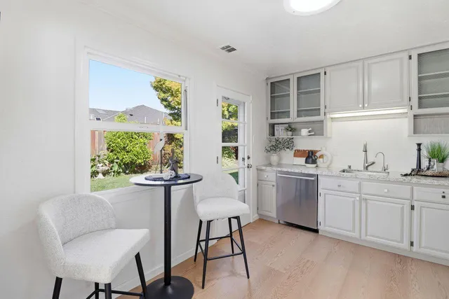 a view of a dining room and livingroom with furniture wooden floor a chandelier