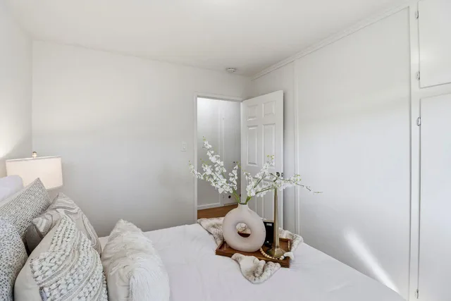 a bedroom with a bed and wooden floor