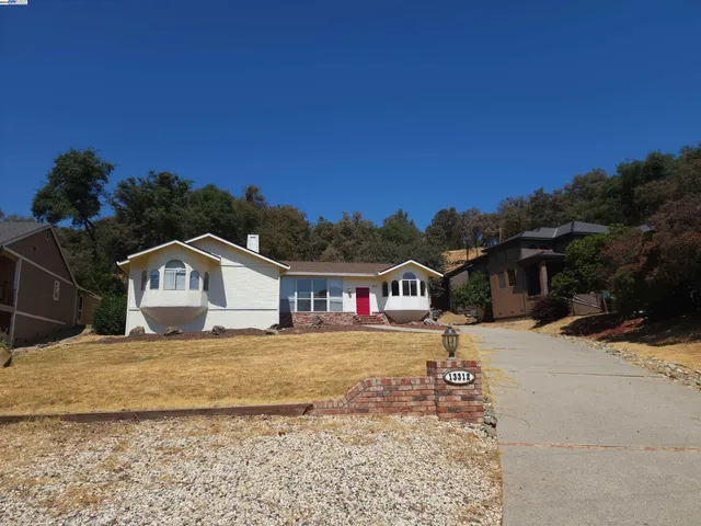 a view of a large house with a big yard and large tree