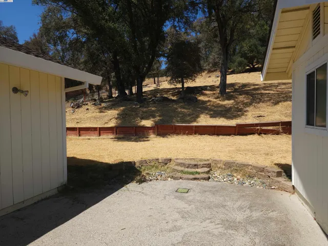a view of a yard with wooden fence