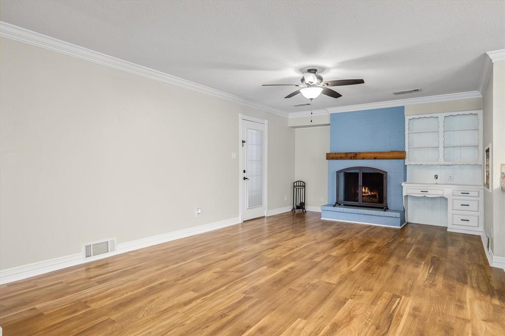 913 Pinson Road Forney, TX 75126 - Photo 5 of 19 Living space with wood burning fireplace and access to back patio.