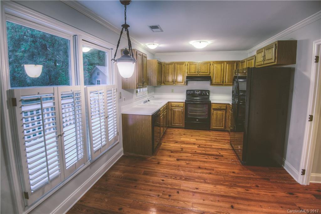 3091 Point Clear Drive Tega Cay, SC 29708 - Photo 7 of 23 a kitchen with stainless steel appliances granite countertop a refrigerator a sink dishwasher a stove and a dining table with wooden floor