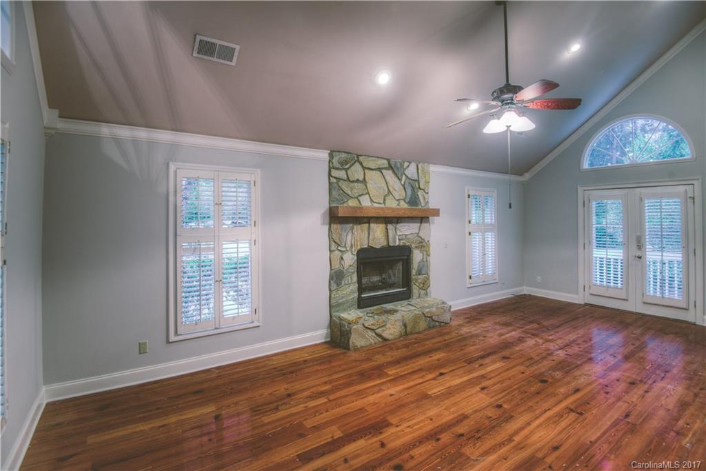3091 Point Clear Drive Tega Cay, SC 29708 - Photo 9 of 23 a view of an empty room with wooden floor fireplace and a window